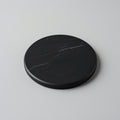 Round black stone coaster on a light gray background