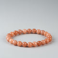 Orange beaded bracelet on a gray background