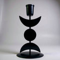 Black metal candle holder with geometric design on a white background