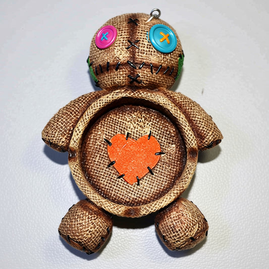 Textile doll with button eyes and an orange heart on a white background