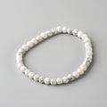 White beaded bracelet on a gray background