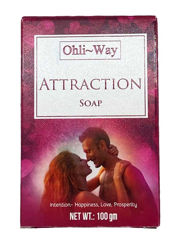 The image features the packaging of Ohli-Way's Attraction Soap, which is designed to promote happiness, love, and prosperity. The packaging is a rectangular card with a purple background, showing an image of a couple embracing.
